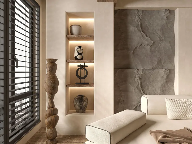 Salon d'un appartement à Outremont : mur de pierre texturée, banquette claire et niches sculptées.