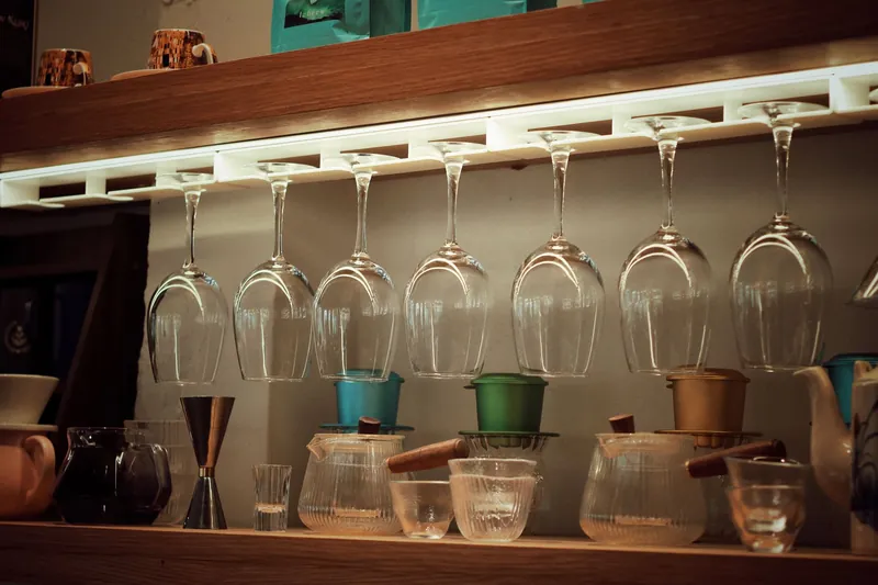 Comptoir d'un bar à vin du Mile-End : verres suspendus et bois sombre chaleureux.